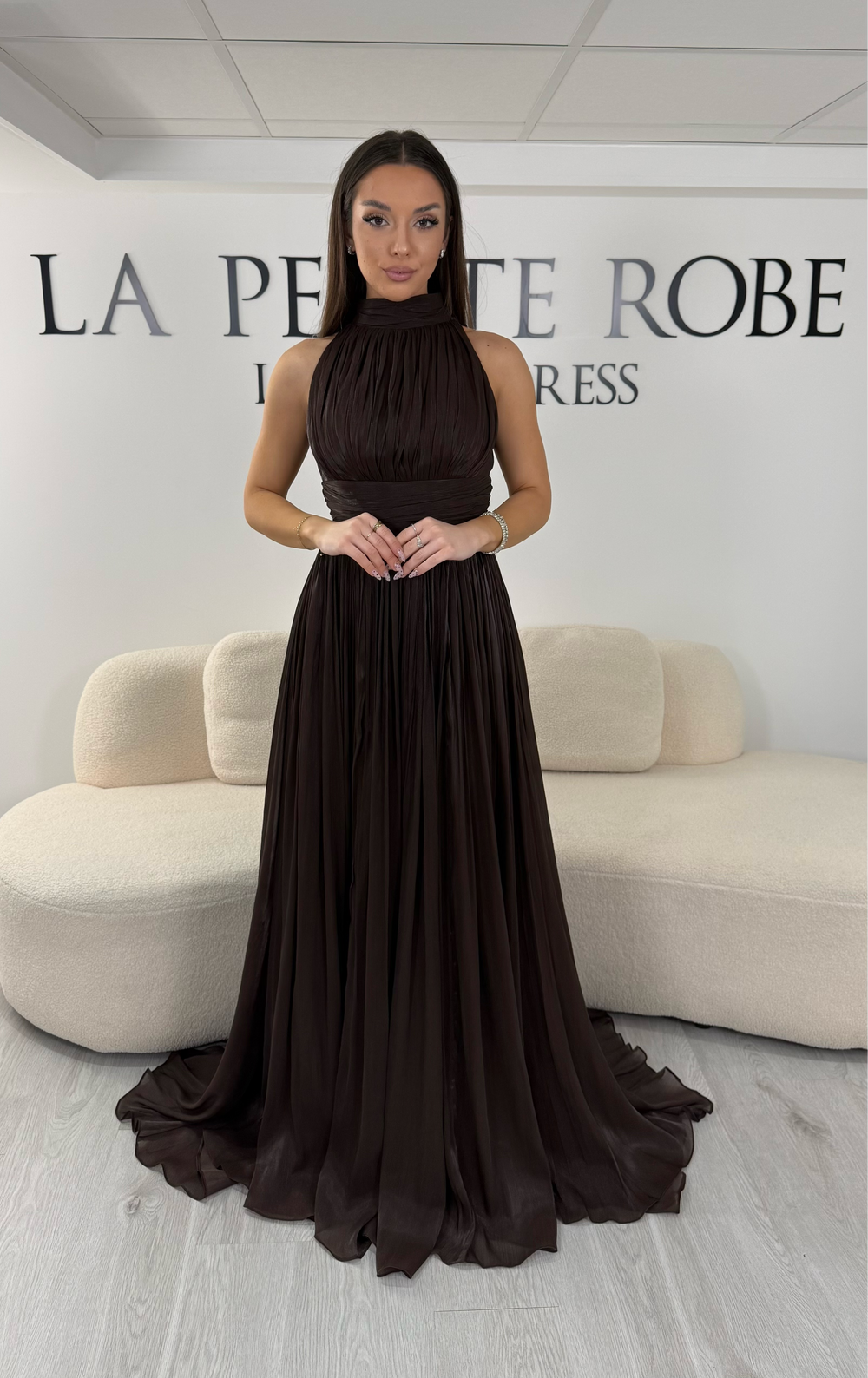 Robe de soirée marron longue plissée avec col montant et coupe sans manches. Une robe élégante sans fente idéale pour mariage, cérémonie et soirée chic.