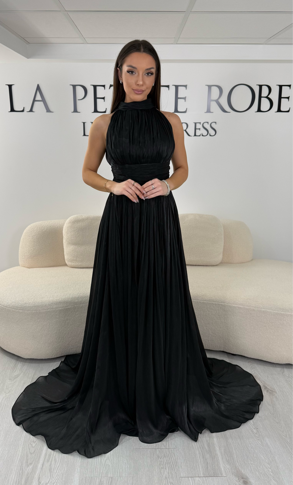 Robe de soirée noire longue plissée avec col montant et coupe sans manches. Une robe élégante sans fente idéale pour mariage, cérémonie et soirée chic.