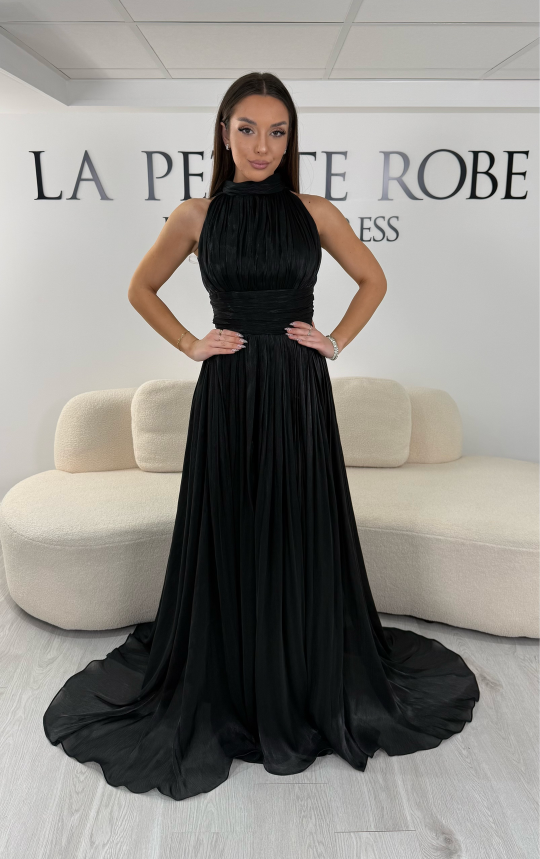Robe de soirée noire longue plissée avec col montant et coupe sans manches. Une robe élégante sans fente idéale pour mariage, cérémonie et soirée chic.