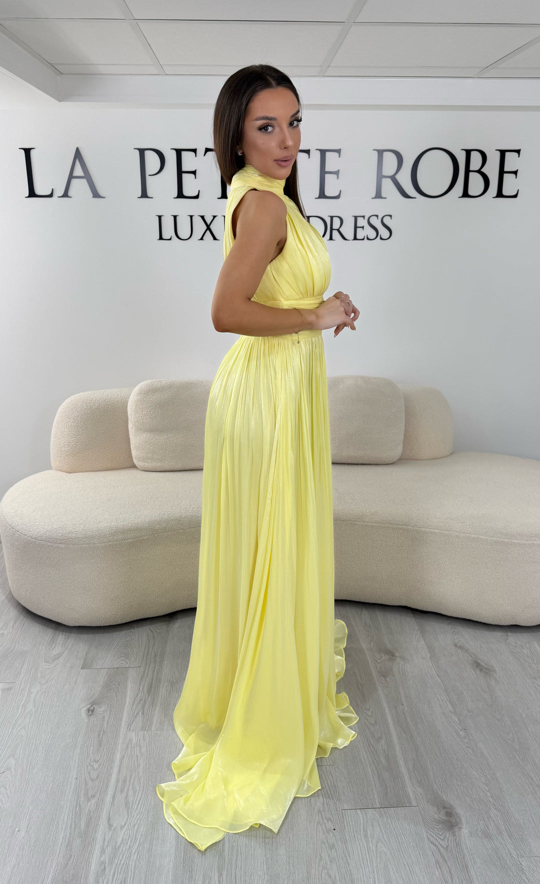 Robe de soirée jaune longue plissée avec col montant et coupe sans manches. Une robe élégante sans fente idéale pour mariage, cérémonie et soirée chic.
