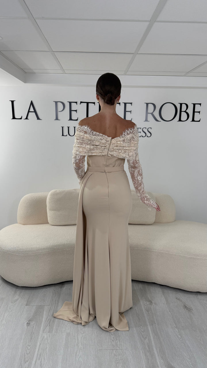 Robe de soirée beige longue avec col bateau en dentelle et manches longues. Une robe élégante sans fente idéale pour mariage, cérémonie et gala.