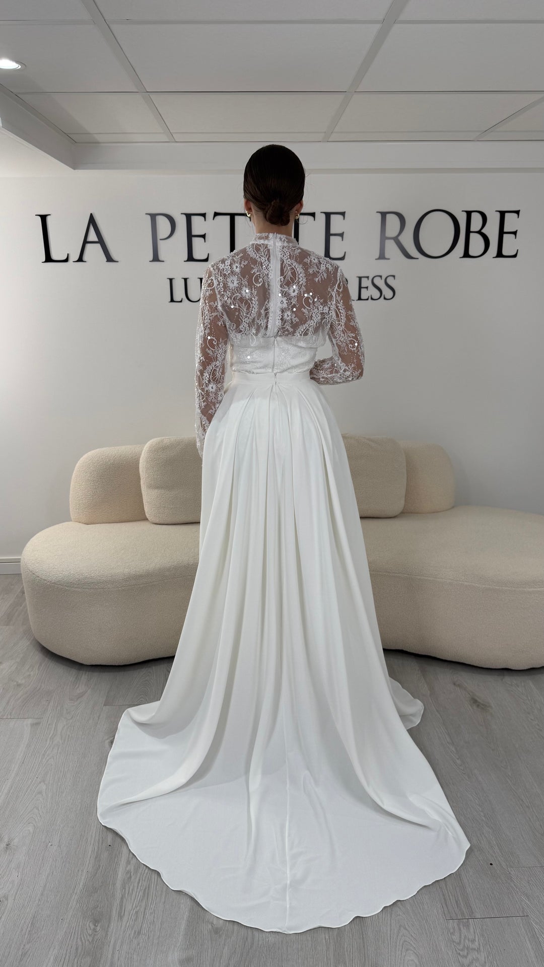 Robe de mariée blanche avec col montant en dentelle, manches longues, boléro amovible et traîne amovible. Une robe élégante sans fente idéale pour votre mariage.