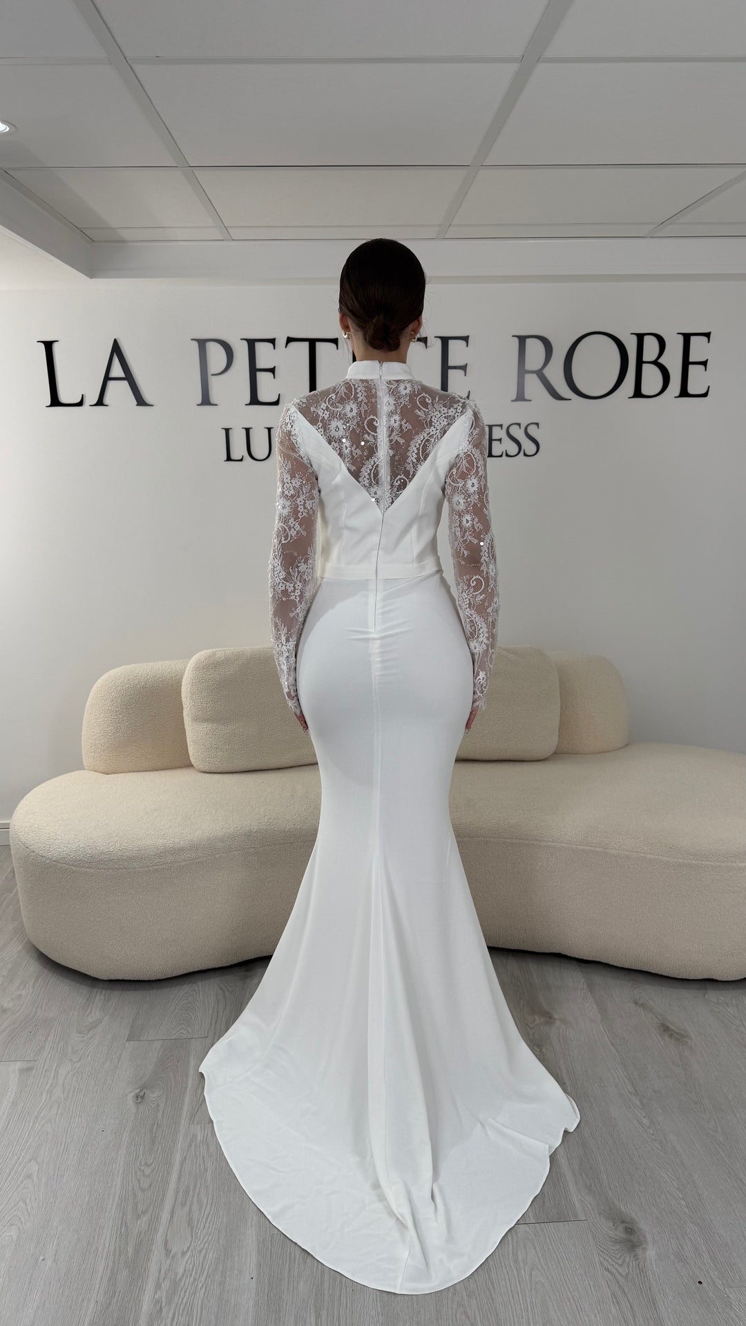 Robe de mariée blanche longue avec col montant, manches longues en dentelle et coupe élégante. Une robe raffinée sans fente idéale pour mariage civil ou cérémonie.