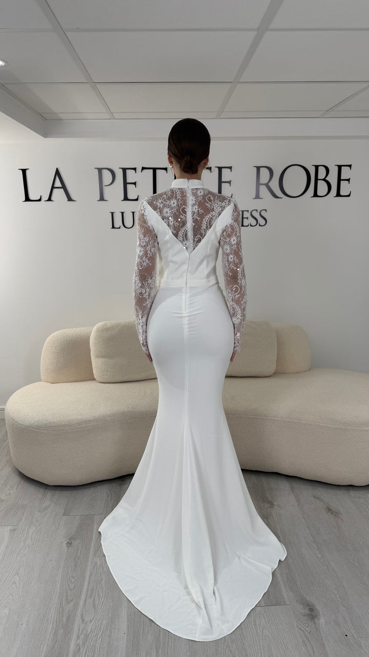 Robe de mariée blanche longue avec col montant, manches longues en dentelle et coupe élégante. Une robe raffinée sans fente idéale pour mariage civil ou cérémonie.