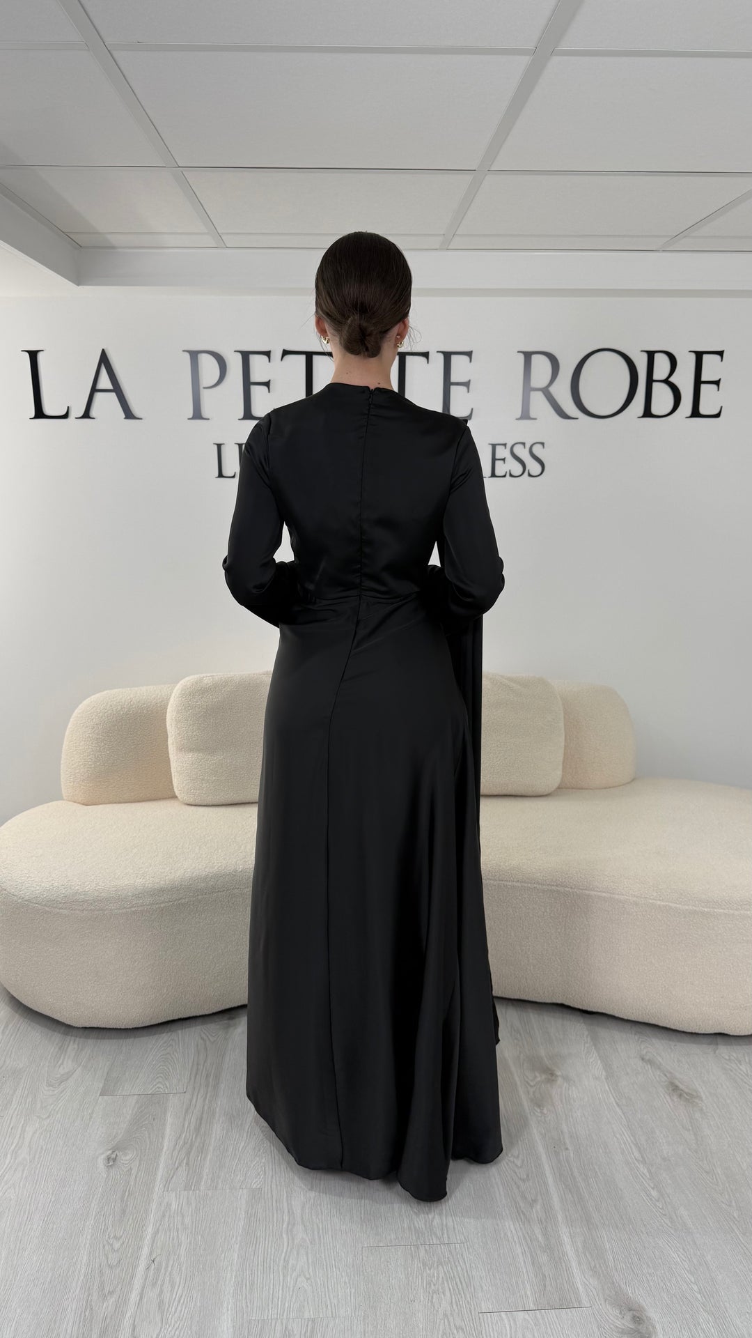 Robe de soirée modeste noire longue avec col rond, manches longues et drapé élégant. Une robe sans fente idéale pour mariage, cérémonie ou demoiselle d'honneur.