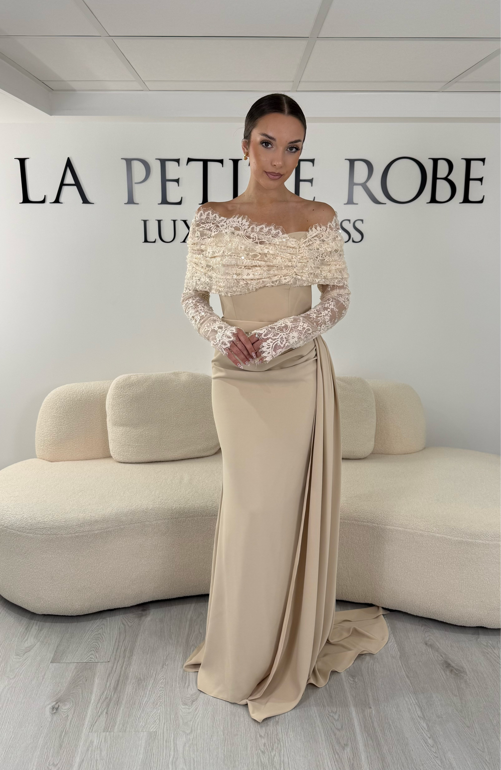 Robe de soirée beige longue avec col bateau en dentelle et manches longues. Une robe élégante sans fente idéale pour mariage, cérémonie et gala.