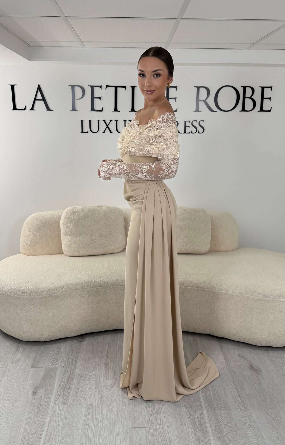 Robe de soirée beige longue avec col bateau en dentelle et manches longues. Une robe élégante sans fente idéale pour mariage, cérémonie et gala.