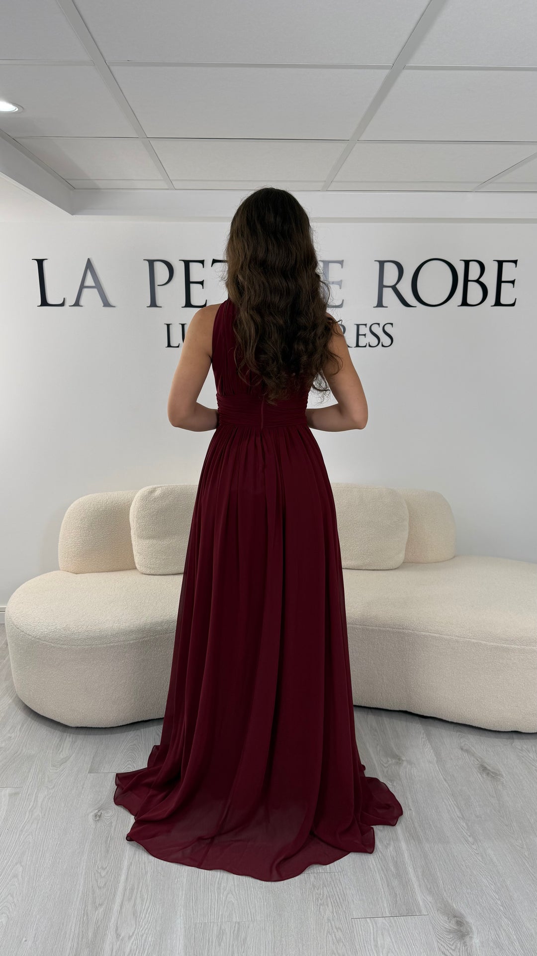 Découvrez cette robe de soirée bordeaux longue et fluide. Sans manche, avec col montant drapé et sans fente, elle offre une allure élégante et raffinée pour toutes vos occasions.