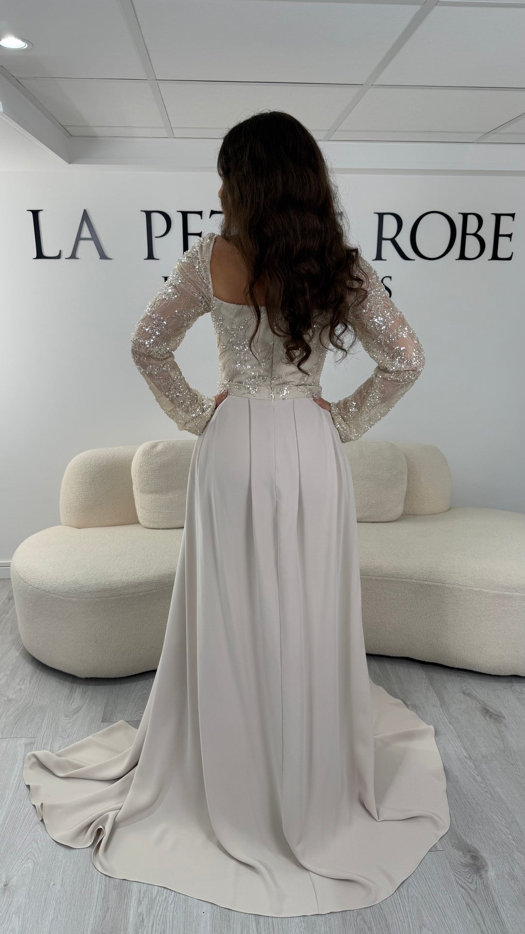 Découvrez cette robe de soirée beige avec col carré, manches longues et traîne amovible. Une robe élégante sans fente, parfaite pour une allure chic et raffinée.