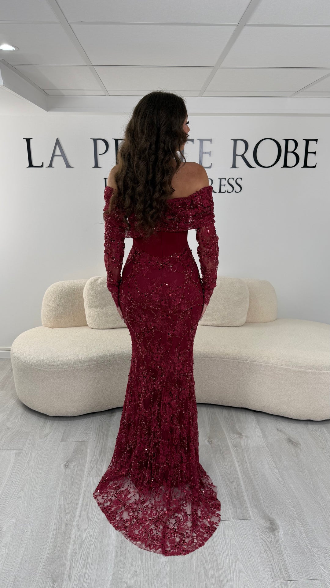 Robe de soirée bordeaux élégante avec col bateau et manches longues en dentelle. Coupe sirène sans fente, idéale pour une allure chic et raffinée.