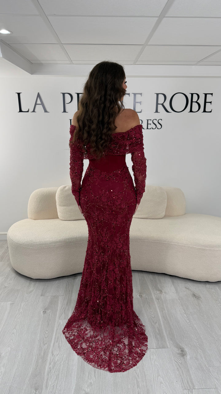 Robe de soirée bordeaux élégante avec col bateau et manches longues en dentelle. Coupe sirène sans fente, idéale pour une allure chic et raffinée.