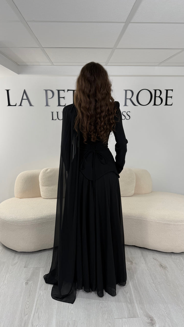 Découvrez cette robe de soirée noire avec col montant, manches longues et voile fluide intégré. Une robe élégante sans fente, parfaite pour mariage, gala et cérémonie.