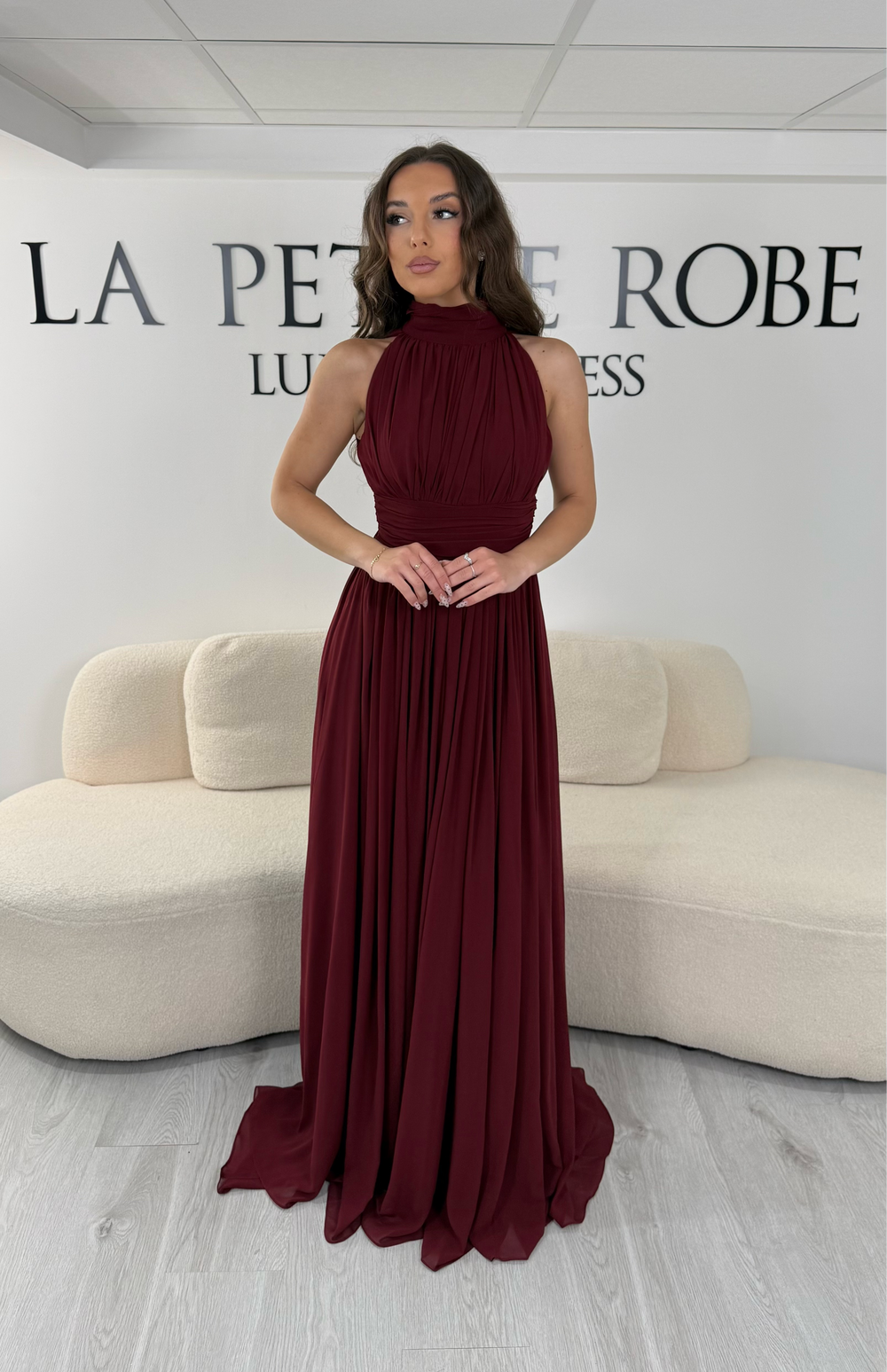 Découvrez cette robe de soirée bordeaux longue et fluide. Sans manche, avec col montant drapé et sans fente, elle offre une allure élégante et raffinée pour toutes vos occasions.