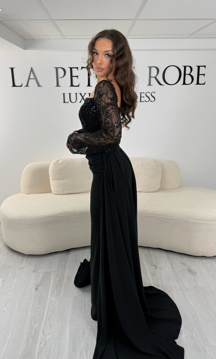 Découvrez cette robe de soirée noire avec col carré, manches longues et traîne amovible. Une robe élégante sans fente, parfaite pour une allure chic et raffinée.