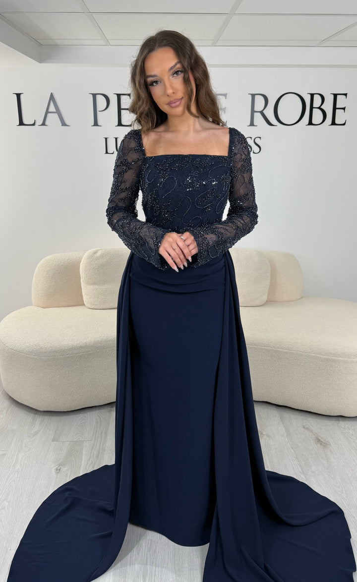 Découvrez cette robe de soirée bleu marine avec col carré, manches longues et traîne amovible. Une robe élégante sans fente, parfaite pour une allure chic et raffinée.