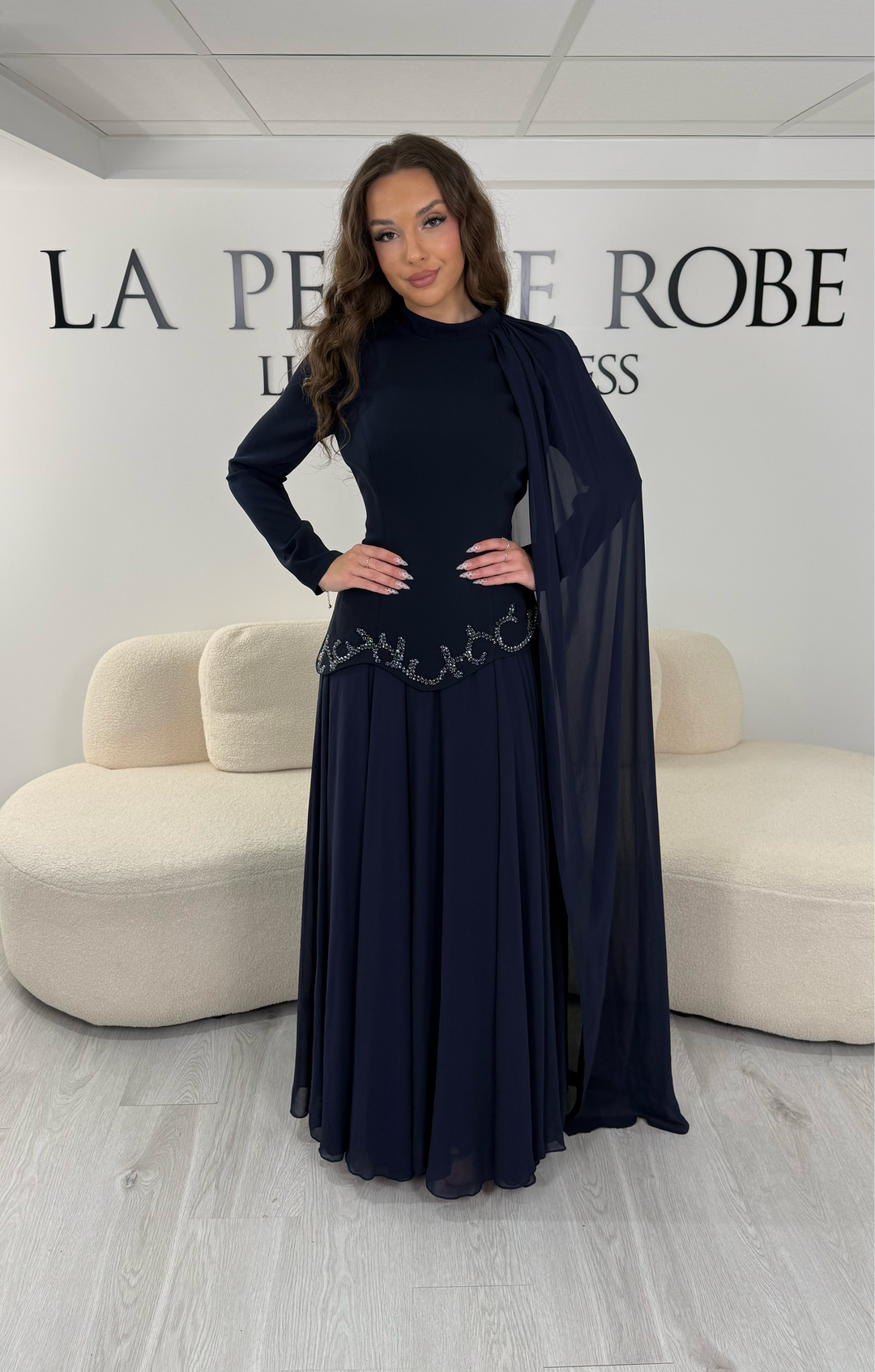 Découvrez cette robe de soirée modeste bleu marine avec col montant, manches longues et voile fluide intégré. Une robe élégante sans fente, idéale pour mariage et cérémonie.