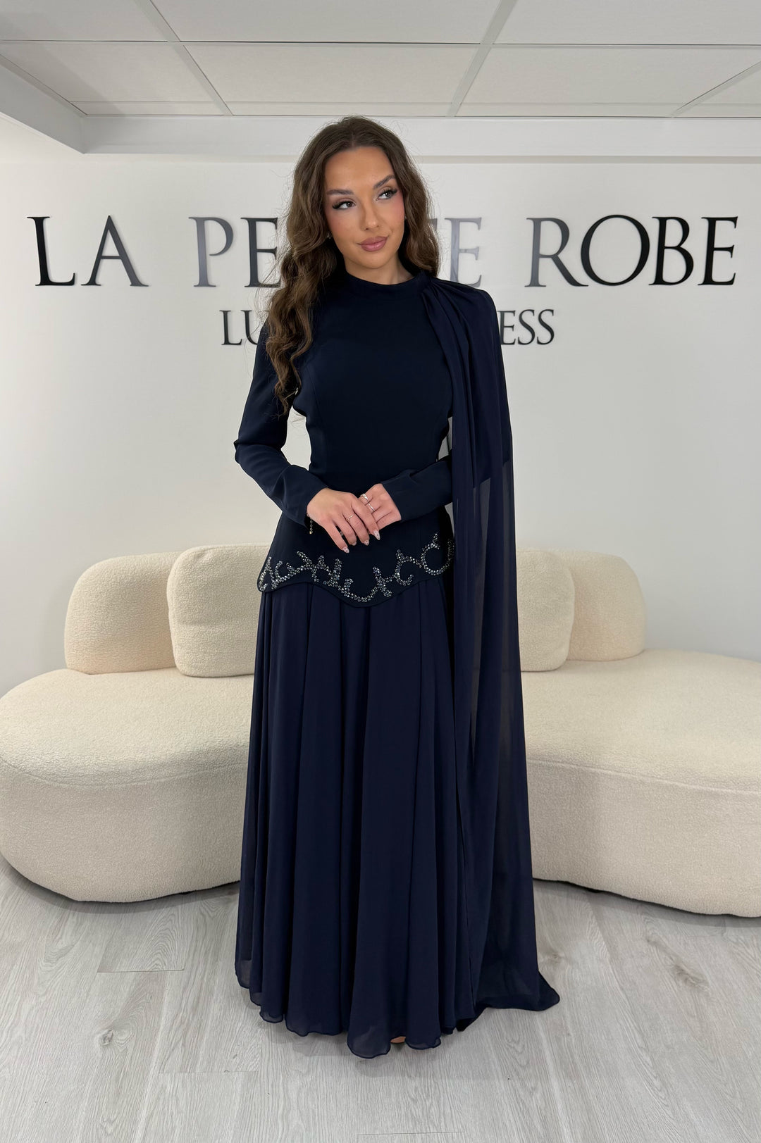 Découvrez cette robe de soirée modeste bleu marine avec col montant, manches longues et voile fluide intégré. Une robe élégante sans fente, idéale pour mariage et cérémonie.