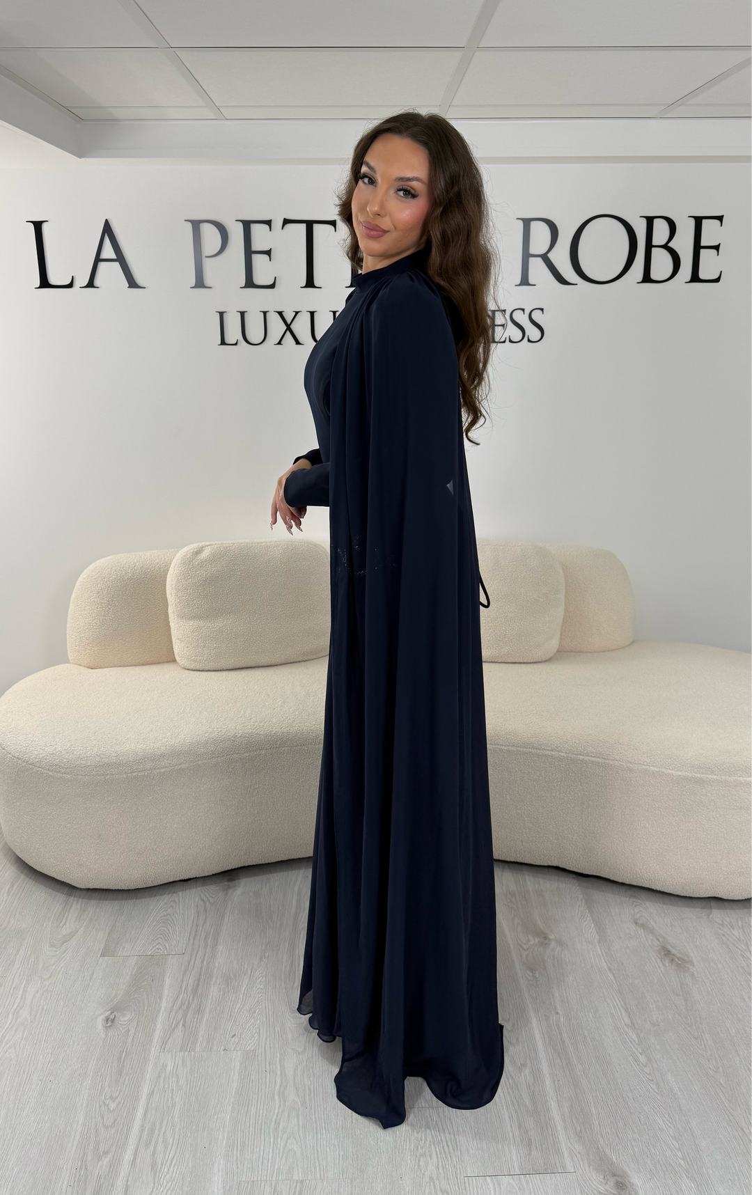Découvrez cette robe de soirée modeste bleu marine avec col montant, manches longues et voile fluide intégré. Une robe élégante sans fente, idéale pour mariage et cérémonie.