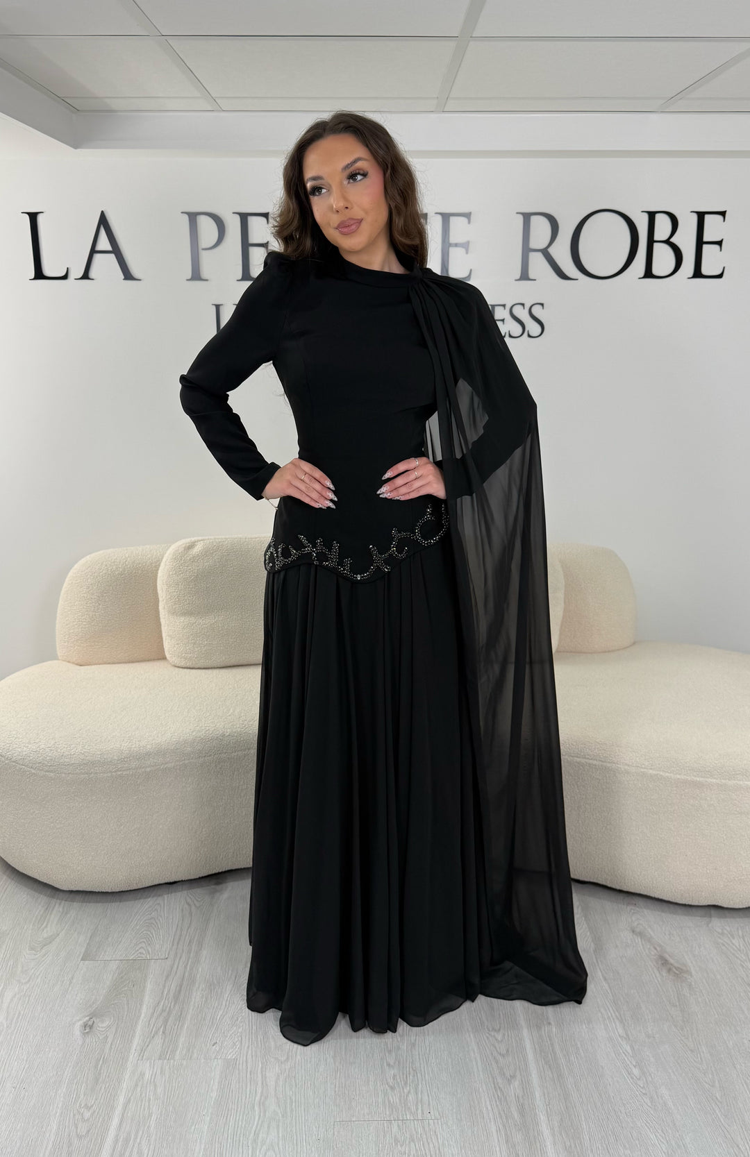 Découvrez cette robe de soirée noire avec col montant, manches longues et voile fluide intégré. Une robe élégante sans fente, parfaite pour mariage, gala et cérémonie.