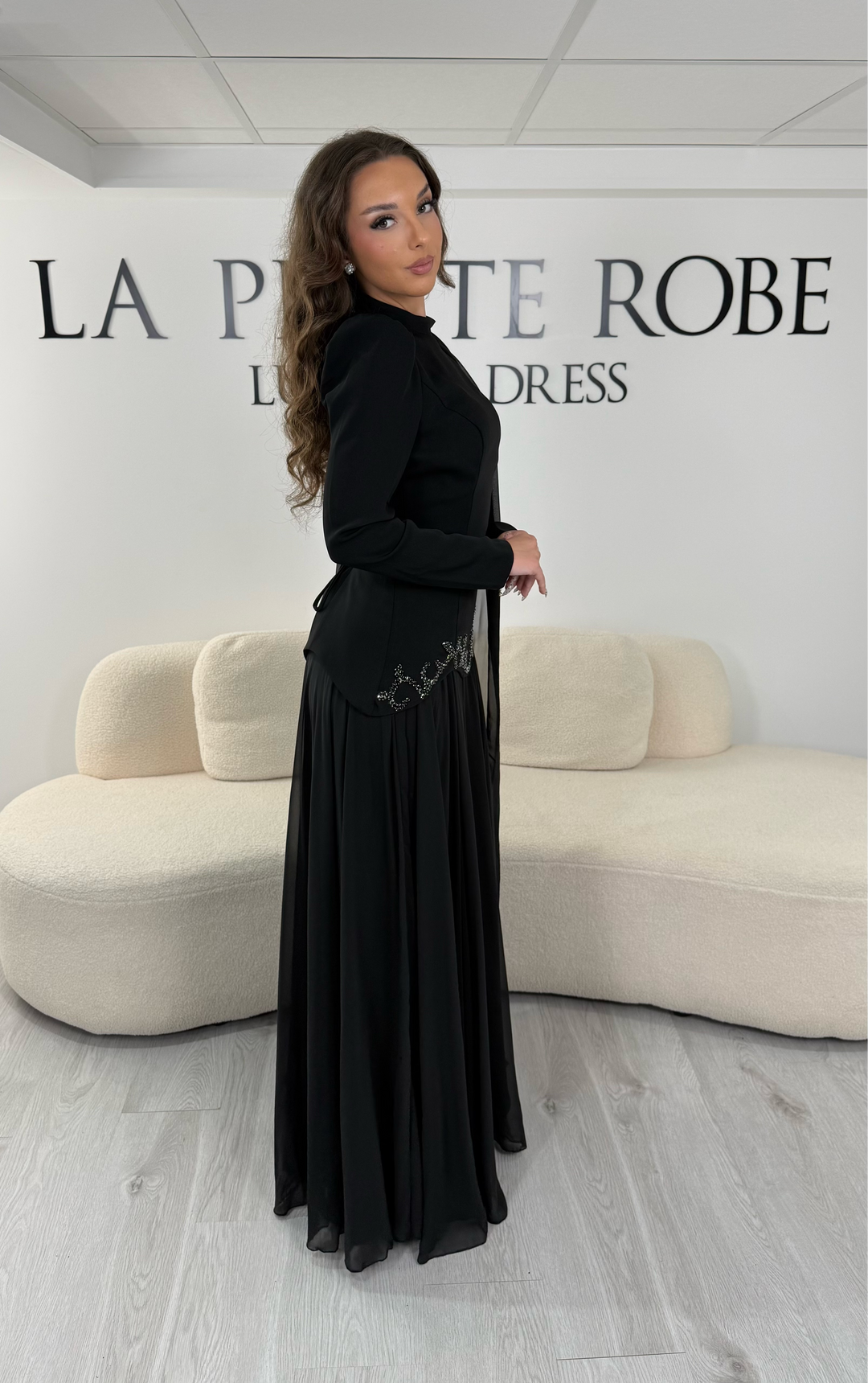 Découvrez cette robe de soirée noire avec col montant, manches longues et voile fluide intégré. Une robe élégante sans fente, parfaite pour mariage, gala et cérémonie.