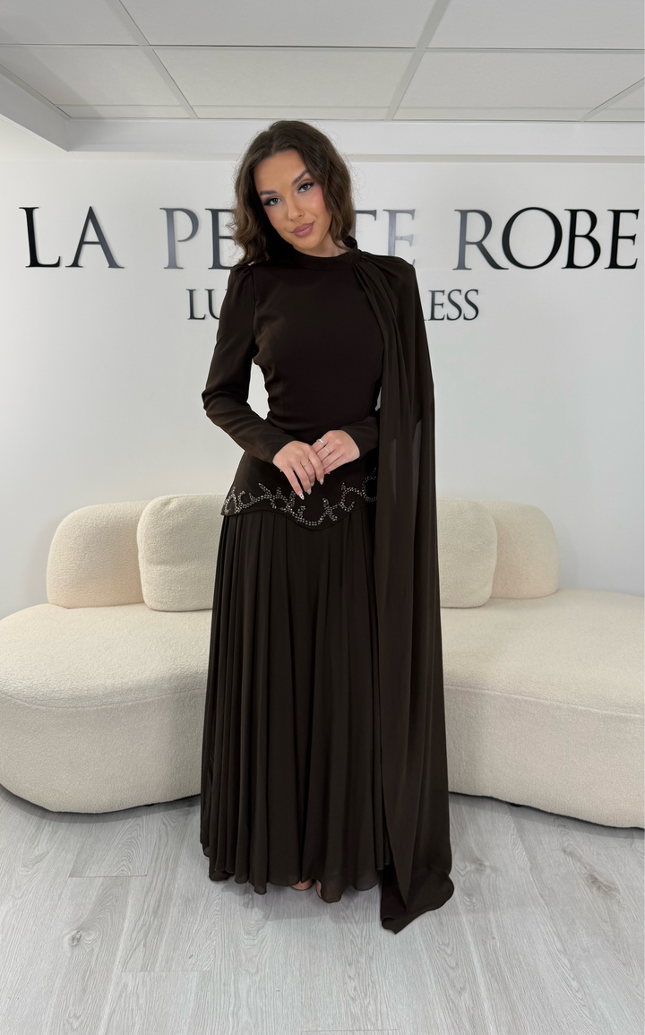 Découvrez cette robe de soirée marron avec col montant, manches longues et voile fluide intégré. Une robe élégante sans fente, parfaite pour mariage, gala et cérémonie.