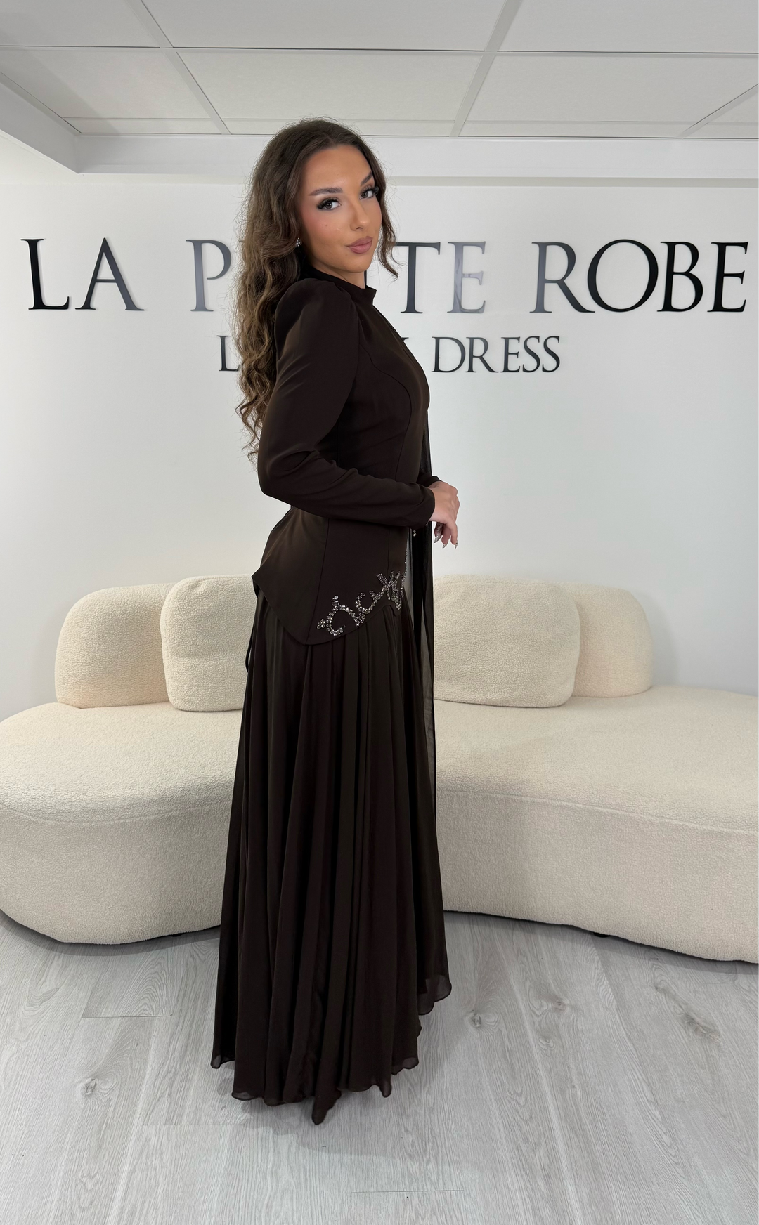 Découvrez cette robe de soirée marron avec col montant, manches longues et voile fluide intégré. Une robe élégante sans fente, parfaite pour mariage, gala et cérémonie.