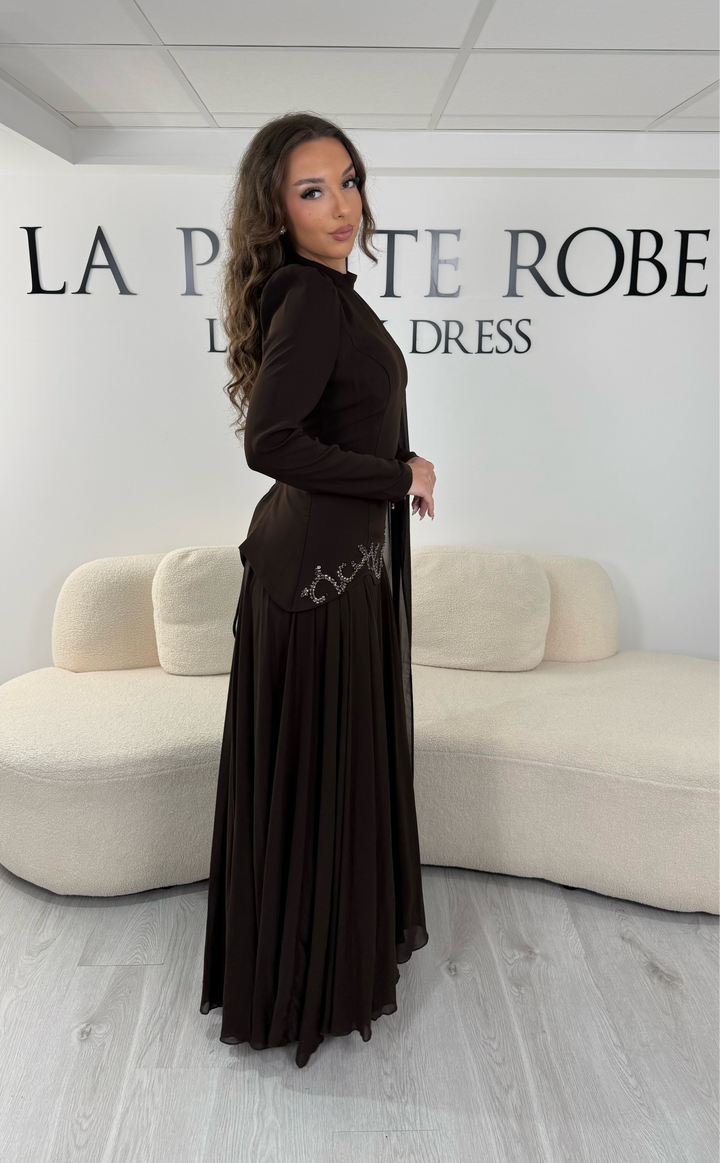 Découvrez cette robe de soirée marron avec col montant, manches longues et voile fluide intégré. Une robe élégante sans fente, parfaite pour mariage, gala et cérémonie.