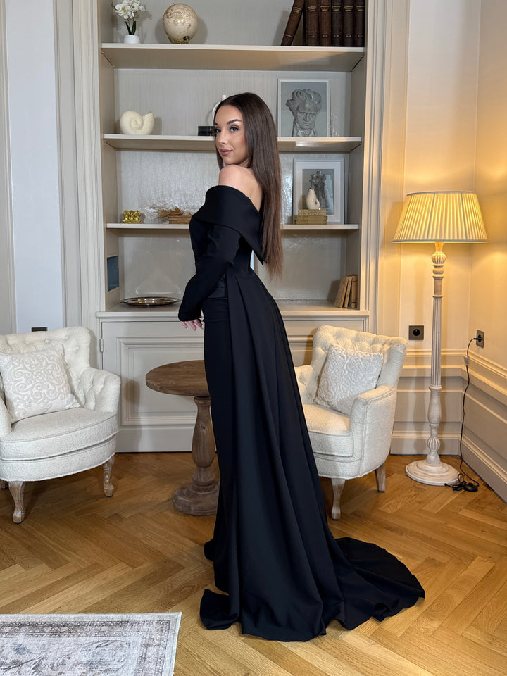 Robe de soirée élégante noire, coupe longue et fluide, col bateau chic et manches longues. Idéale pour mariage, gala et événements raffinés.