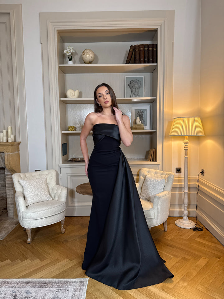 Longue robe de soirée noire élégante, col bustier sans manches, coupe fluide sans fente. Une robe chic et intemporelle pour vos soirées.