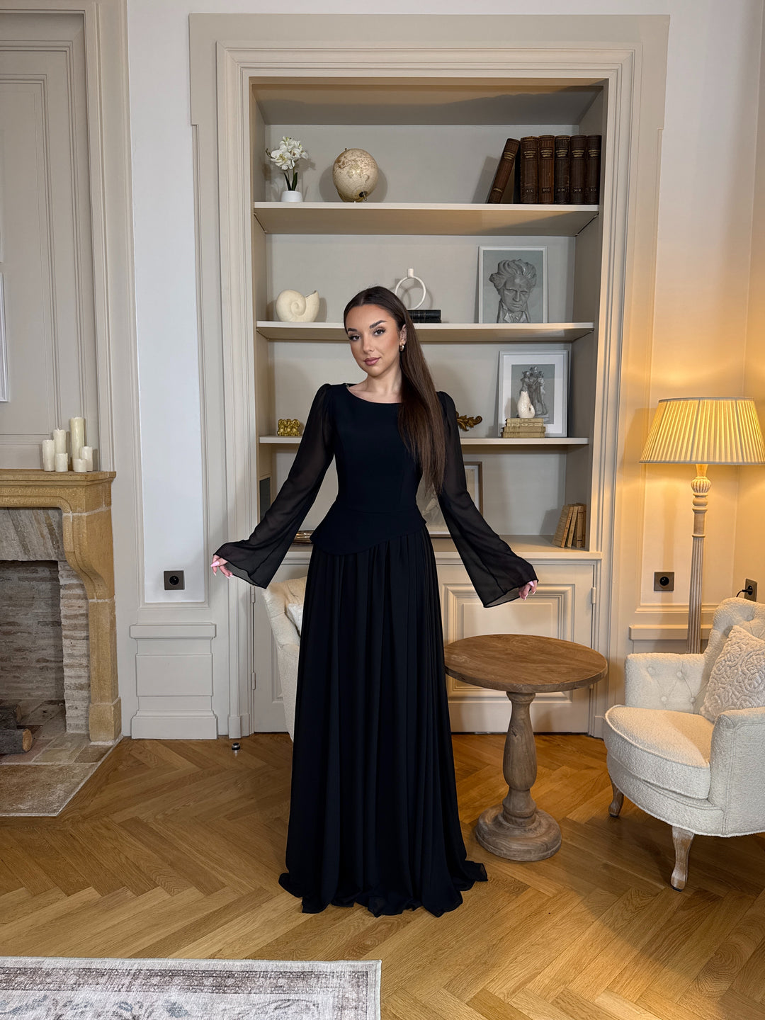 Robe de soirée noir élégante avec col rond et manches longues, coupe fluide sans fente. Une robe chic et intemporelle pour vos soirées.