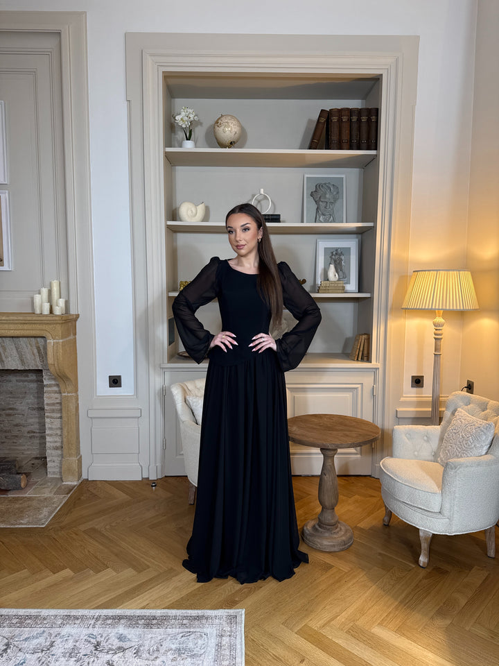 Robe de soirée noir élégante avec col rond et manches longues, coupe fluide sans fente. Une robe chic et intemporelle pour vos soirées.
