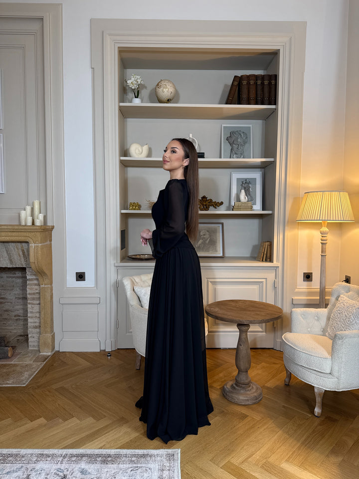 Robe de soirée noir élégante avec col rond et manches longues, coupe fluide sans fente. Une robe chic et intemporelle pour vos soirées.