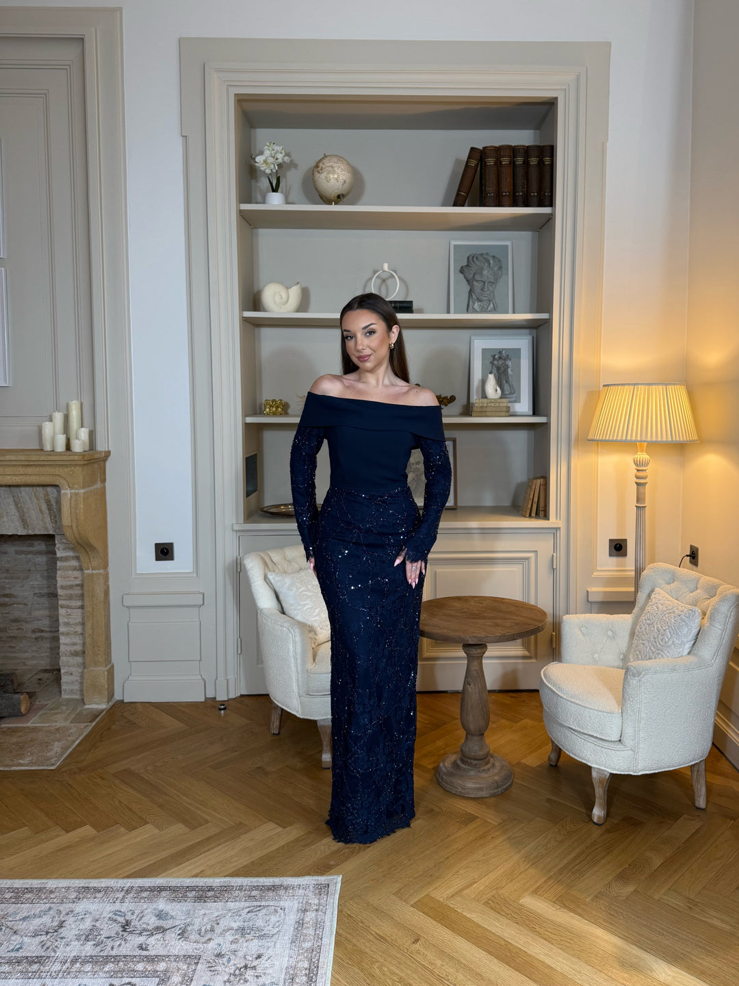 Robe de soirée bleu marine élégante avec col bateau, manches longues et fente à l’arrière. Une robe chic et raffinée pour vos soirées.