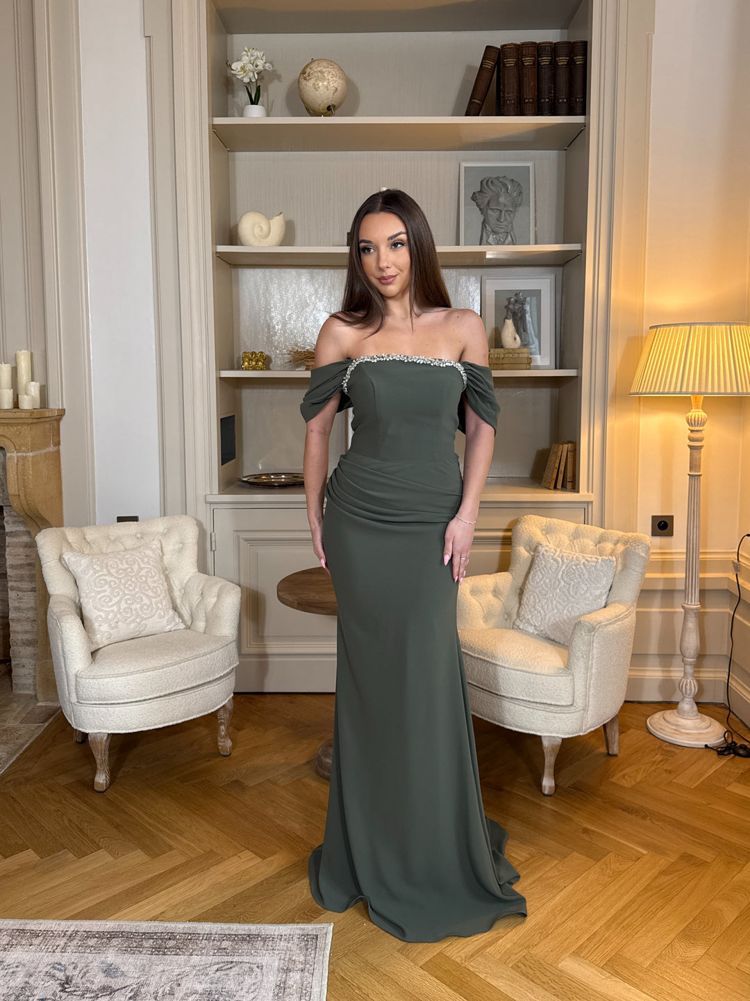 Robe de soirée kaki chic au col bateau, coupe longue et fluide sans fente. Une robe élégante et moderne pour vos soirées.