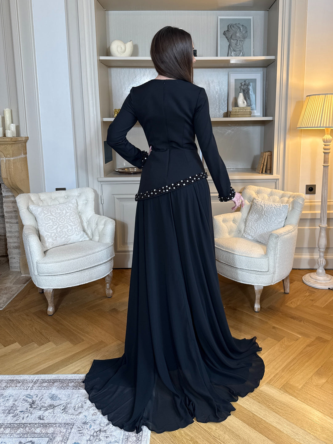 Robe de soirée élégante noire, coupe longue et fluide, col bateau chic et manches longues. Idéale pour mariage, gala et événements raffinés.