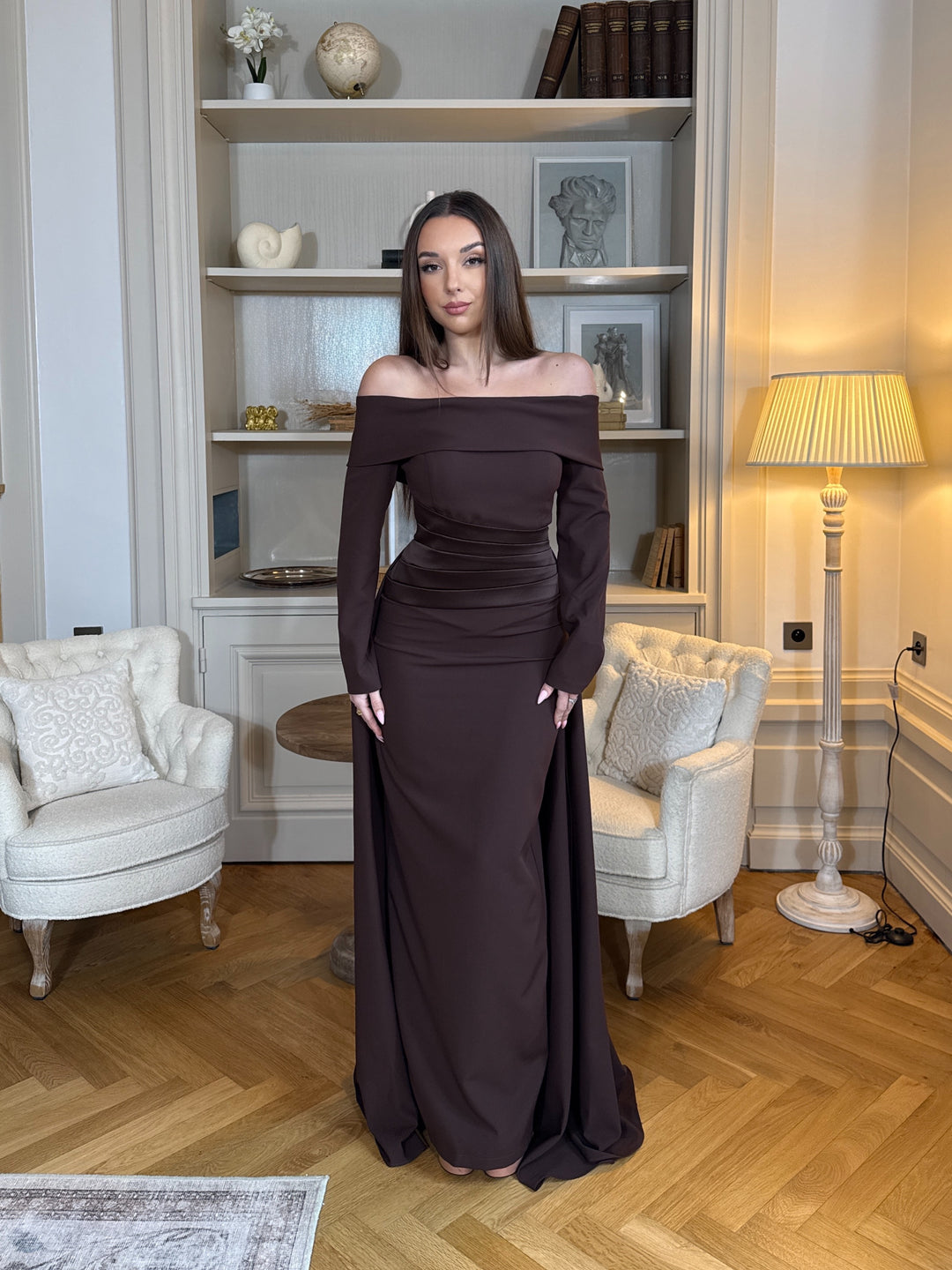 Robe de soirée élégante marron, coupe longue et fluide, col bateau chic et manches longues. Idéale pour mariage, gala et événements raffinés.