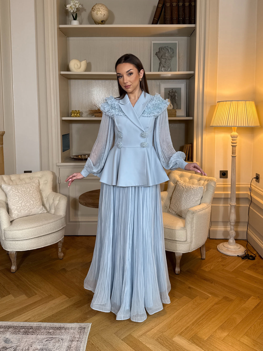 Ensemble blazer avec jupe bleu chic, manches longues plissées et détails floraux. Élégant, fluide et raffiné, parfait pour mariage ou cérémonie.