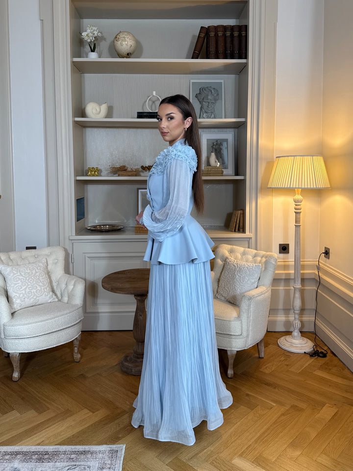 Ensemble blazer avec jupe bleu chic, manches longues plissées et détails floraux. Élégant, fluide et raffiné, parfait pour mariage ou cérémonie.