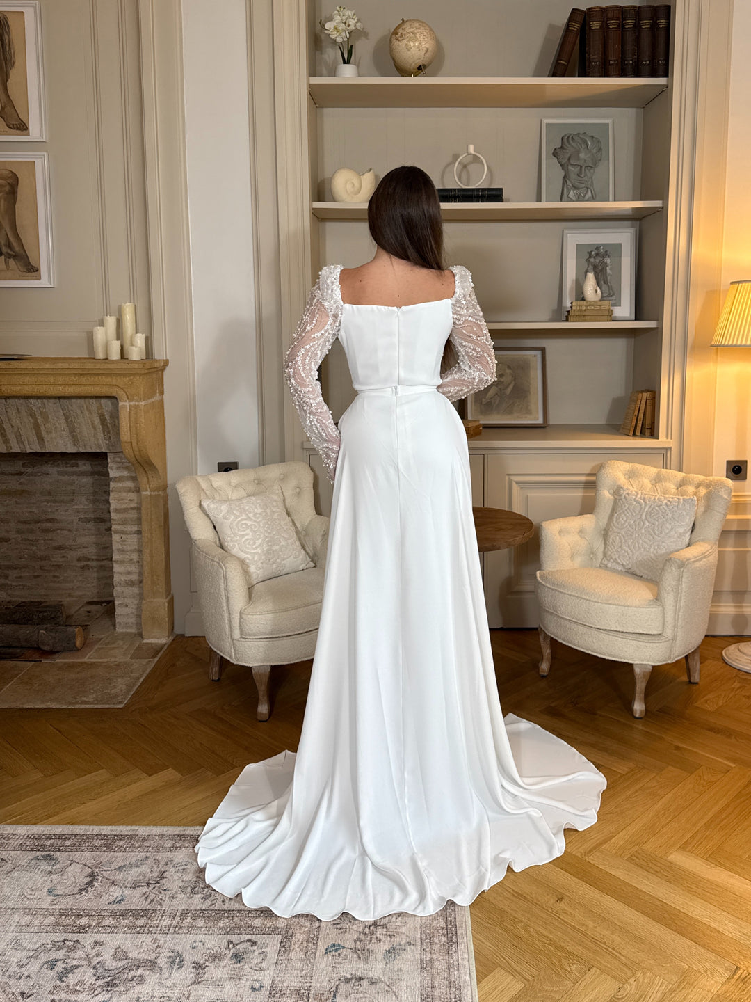 Découvrez une élégante robe de mariée blanc avec manches longues ornées, coupe flatteuse et tissu fluide, parfaite pour sublimer votre cérémonie.