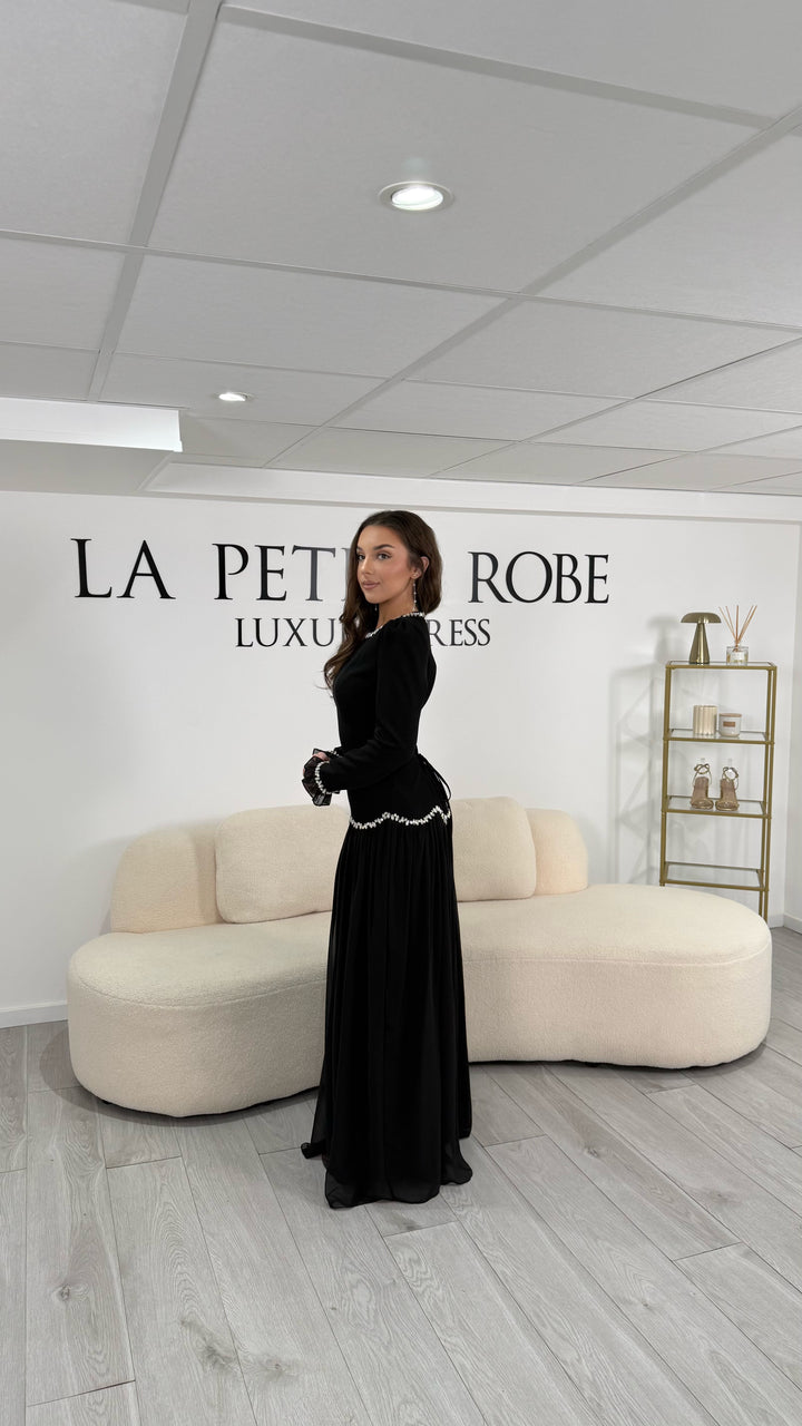 Robe de soirée modeste noire élégante, longue et fluide. Col rond, manches longues, sans fente. Parfaite pour mariage et soirées chics.