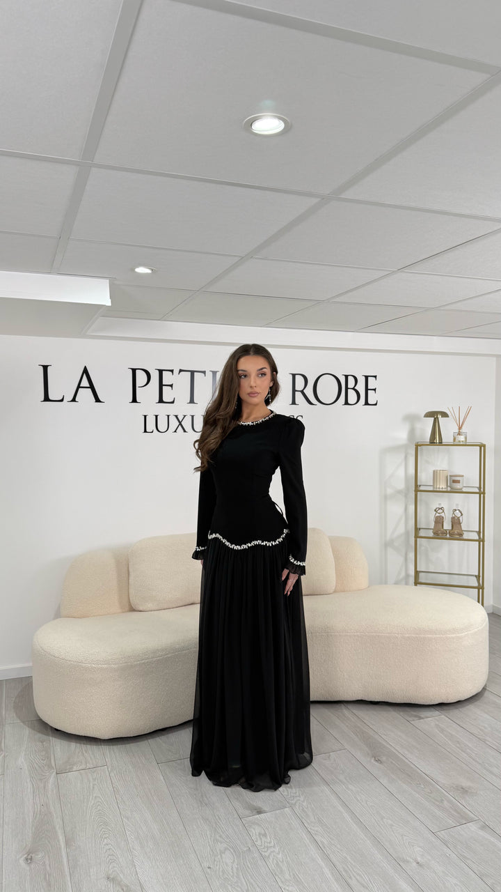 Robe de soirée modeste noire élégante, longue et fluide. Col rond, manches longues, sans fente. Parfaite pour mariage et soirées chics.