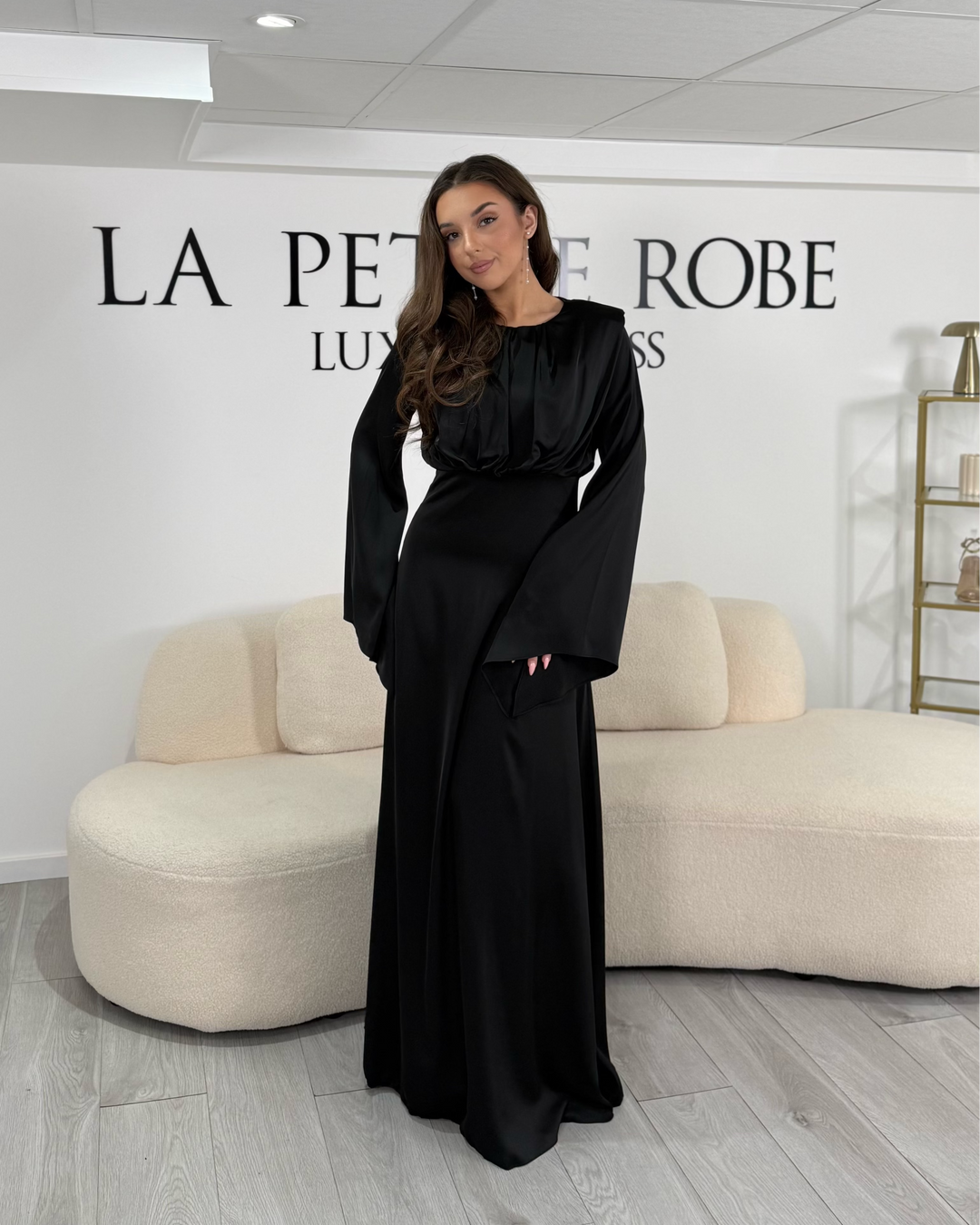 Longue robe de soirée modeste noire, fluide et élégante. Col rond, manches longues, sans fente. Idéale pour mariage et soirée chic.
