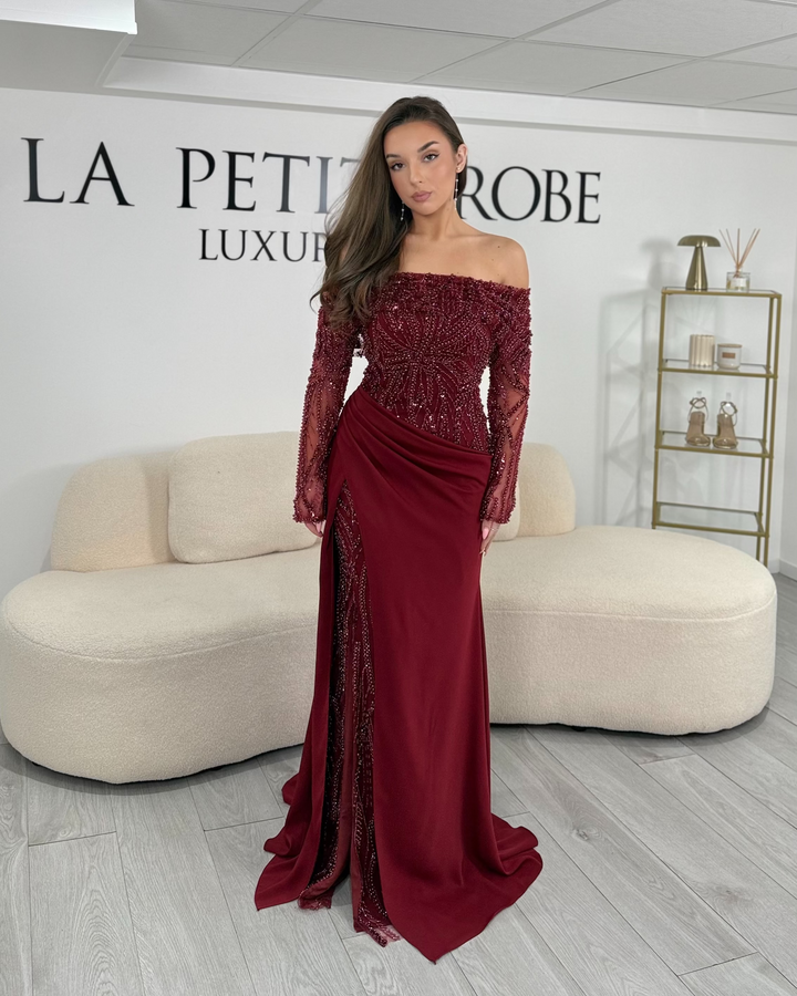Robe de soirée bordeaux chic, longue et élégante, sans fente, avec col bardot et manches longues brodées. Idéale pour gala et événements raffinés.