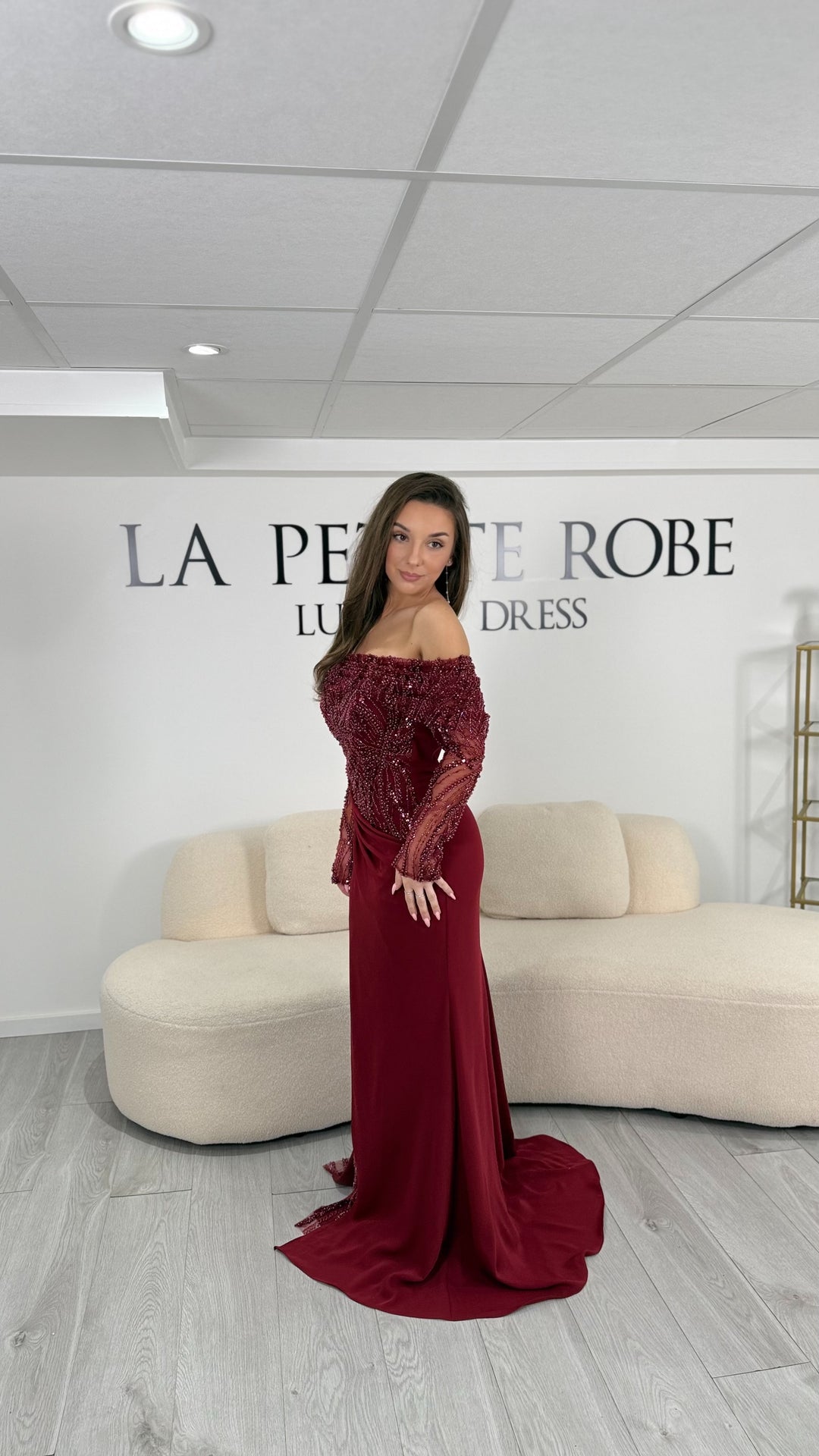 Robe de soirée bordeaux chic, longue et élégante, sans fente, avec col bardot et manches longues brodées. Idéale pour gala et événements raffinés.