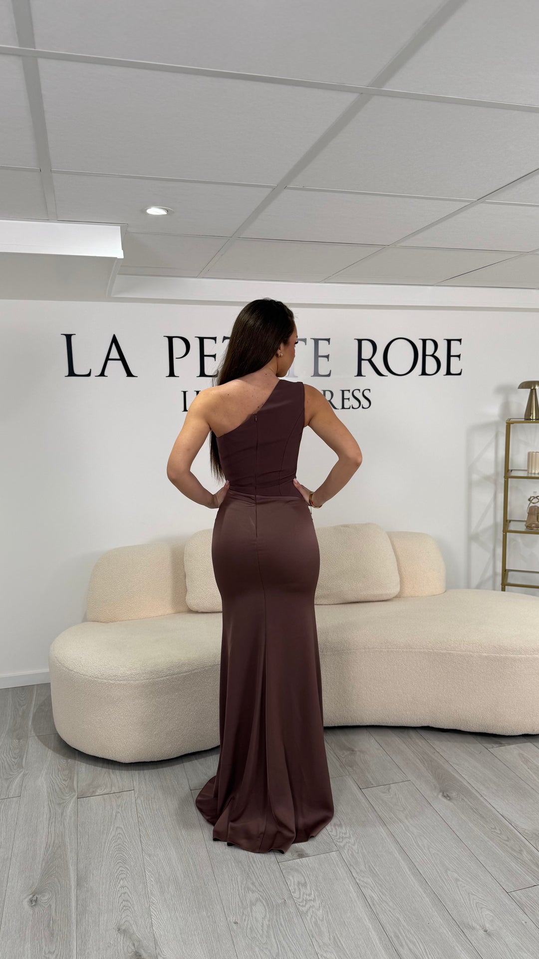 Robe de soirée marron chic, longue et élégante, sans fente, col asymétrique et sans manche. Une robe raffinée pour vos soirées habillées.