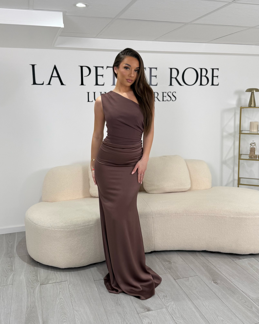 Robe de soirée marron chic, longue et élégante, sans fente, col asymétrique et sans manche. Une robe raffinée pour vos soirées habillées.