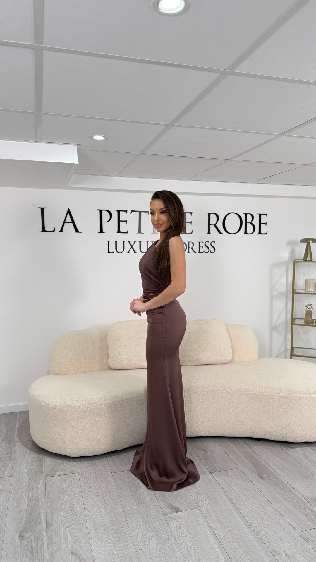 Robe de soirée marron chic, longue et élégante, sans fente, col asymétrique et sans manche. Une robe raffinée pour vos soirées habillées.