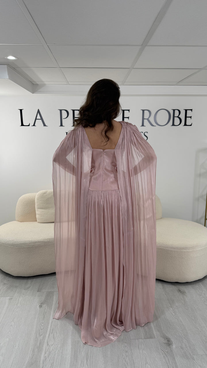 Robe de soirée rose élégante longue, col en V drapé, sans manche et dotée d’une fente raffinée. Coupe fluide et féminine idéale pour mariages et cérémonies.