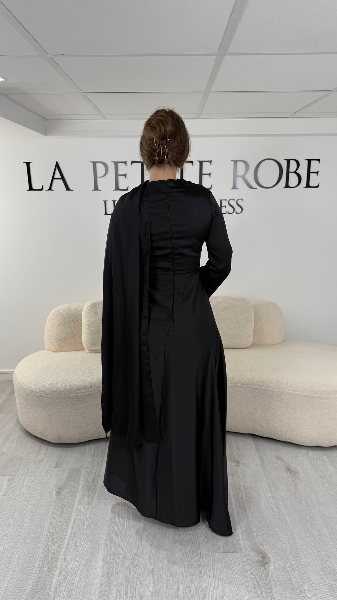 Robe de soirée modeste noire longue avec col rond, manches longues et drapé élégant. Une robe sans fente idéale pour mariage, cérémonie ou demoiselle d'honneur.