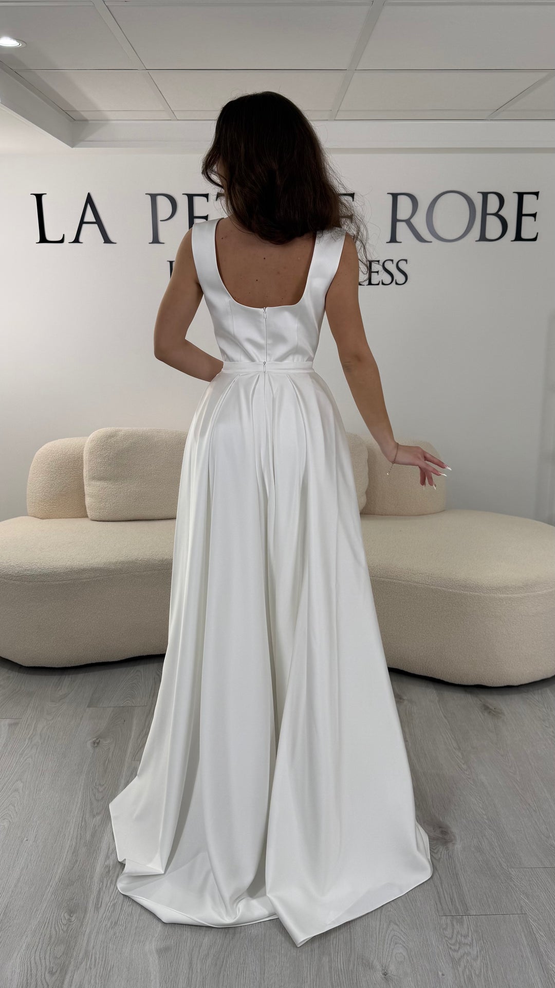 Robe de mariée blanche longue avec col carré et coupe sans manche. Sans fente et avec traîne amovible élégante, idéale pour cérémonie et réception.